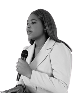 Black and white photo of a woman speaking into a microphone wearing a white blazer