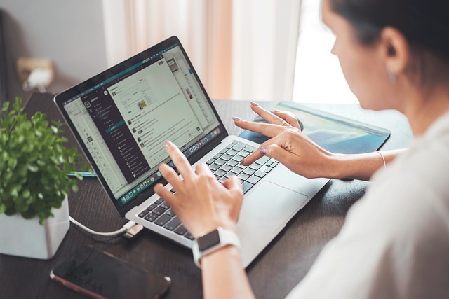 A woman is using a laptop, engaging with a messaging app